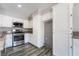 Updated kitchen featuring stainless steel appliances, white cabinetry, granite countertops, and modern wood-look tile at 2046 Waverly Cir, Henderson, NV 89014