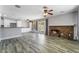 The open-concept living area features wood-look floors, a stone fireplace, and access to the outdoor patio at 2046 Waverly Cir, Henderson, NV 89014