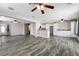 Open-concept living room with wood-look tile, ceiling fans, and ample natural light, seamlessly connecting living spaces at 2046 Waverly Cir, Henderson, NV 89014