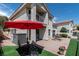 An inviting backyard patio with outdoor seating and a vibrant red umbrella offers a relaxing retreat at 2529 Seascape Dr, Las Vegas, NV 89128