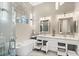 Elegant bathroom featuring dual sinks, arched window, chandelier lighting, and pull out shelving at 2529 Seascape Dr, Las Vegas, NV 89128