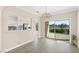 Bright dining area with chandelier, tile floors, slider door to the backyard, and pass through to kitchen at 2529 Seascape Dr, Las Vegas, NV 89128