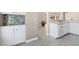 Kitchen with white cabinets, light countertops, decorative tile backsplash, and tile floor at 2529 Seascape Dr, Las Vegas, NV 89128