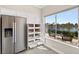 Modern kitchen with stainless steel refrigerator, pantry with pull out shelves, and lake views at 2529 Seascape Dr, Las Vegas, NV 89128