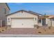 Charming single-story home with a two-car garage, brick driveway, and desert landscaping at 2611 Freya Valley St, Las Vegas, NV 89156