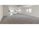 Spacious living room with neutral carpet, ceiling fan, and view into the kitchen and backyard at 2611 Freya Valley St, Las Vegas, NV 89156