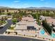 Stunning aerial view of a house with a pool, solar panels, and a lush backyard, situated in a scenic landscape at 308 Kingsclear Ct, Las Vegas, NV 89145