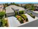 An elevated view of a single-story home with a three-car garage and lush, manicured front yard at 308 Kingsclear Ct, Las Vegas, NV 89145