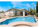 Stunning backyard oasis featuring a pool, spa, covered patio, and lush landscaping for ultimate relaxation at 308 Kingsclear Ct, Las Vegas, NV 89145