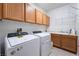 Convenient laundry room with washer, dryer, ample cabinet space, and a utility sink at 308 Kingsclear Ct, Las Vegas, NV 89145