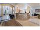 Open-concept living space with stone-accented breakfast bar, tile flooring, and view of the entry at 308 Kingsclear Ct, Las Vegas, NV 89145