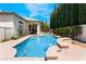 Gorgeous pool with attached jacuzzi and waterfall feature amid well-manicured backyard and greenery at 308 Kingsclear Ct, Las Vegas, NV 89145