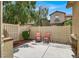 Cozy fenced back patio with chairs, barbecue, and private outdoor space, perfect for relaxing or entertaining at 3141 Monet Sunrise Ave, Henderson, NV 89044