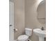 Clean bathroom features a white toilet, vanity, and a round mirror at 3141 Monet Sunrise Ave, Henderson, NV 89044