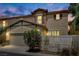 Inviting two-story home with a landscaped front yard, and warm exterior lighting at 3141 Monet Sunrise Ave, Henderson, NV 89044