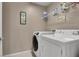 Bright laundry room features a washing machine, a dryer, and shelves at 3141 Monet Sunrise Ave, Henderson, NV 89044