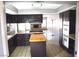 Traditional kitchen with island, dark cabinets, and brick accent around gas cooktop at 3144 Downing Pl, Las Vegas, NV 89121