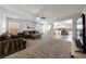 Open-concept living room featuring plush carpeting, a ceiling fan, and easy access to the kitchen and dining area at 3367 Popcorn Flower St, Las Vegas, NV 89117