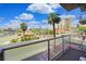 A balcony view featuring palm trees and city views under a bright blue, partly cloudy sky at 353 E Bonneville Ave # 215, Las Vegas, NV 89101