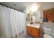 Bright bathroom with a shower featuring a white curtain, vanity, decorative artwork, and toilet at 353 E Bonneville Ave # 215, Las Vegas, NV 89101
