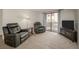 Spacious living room with neutral carpet, leather recliners, and patio access at 3791 Desert Marina Dr # 109, Laughlin, NV 89029