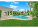 Beautiful backyard with lush green grass, a sparkling pool, and a covered patio area at 3846 Biltmore Bay St, Las Vegas, NV 89147