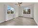 Bright bedroom featuring two large windows, neutral walls, ceiling fan, and light wood-look flooring at 3846 Biltmore Bay St, Las Vegas, NV 89147