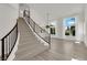 Bright foyer features hardwood floors, an elegant staircase with iron railing and large windows at 3846 Biltmore Bay St, Las Vegas, NV 89147