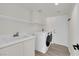 Bright laundry room featuring a modern washer and dryer, white cabinets, and a sink at 3846 Biltmore Bay St, Las Vegas, NV 89147