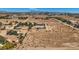 Expansive aerial view of desert property with mature trees, outbuildings, and distant city views at 4075 W Torino Ave, Las Vegas, NV 89139