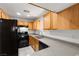 Functional kitchen equipped with black appliances, wood cabinets, and durable countertops for easy meal preparation at 4076 Rocky Beach Dr, Las Vegas, NV 89115