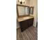 Bathroom with a vanity, decorative framed mirrors, modern fixtures, and wood-look tile flooring at 4308 Apex Dr, Las Vegas, NV 89147