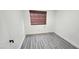 A clean, finished bedroom with wood-look tile flooring and a window with a brown shade at 4308 Apex Dr, Las Vegas, NV 89147