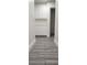 Hallway with wood-look tile flooring, white walls and cabinets leading to an open doorway at 4308 Apex Dr, Las Vegas, NV 89147