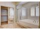 The bathroom features a tub with tile surround, a glass-enclosed shower, and mirrored closet doors at 4334 Libbiano Ct, Las Vegas, NV 89141