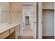 A bathroom with a single sink vanity and a tiled floor offers a glimpse into a closet at 4334 Libbiano Ct, Las Vegas, NV 89141