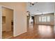 An expansive living area with wood-look floors leading to a laundry area and featuring a fireplace and neutral color palette at 4334 Libbiano Ct, Las Vegas, NV 89141