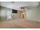A spacious carpeted main bedroom with neutral paint, a ceiling fan, and a wall-mounted television at 4334 Libbiano Ct, Las Vegas, NV 89141