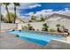 Backyard features a refreshing in-ground pool surrounded by palm trees and a privacy wall at 4334 Libbiano Ct, Las Vegas, NV 89141