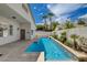 Backyard pool featuring a clear blue pool with a tiled border, palm trees, and a white privacy wall at 4334 Libbiano Ct, Las Vegas, NV 89141