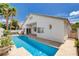 Backyard oasis featuring a sparkling pool, covered patio, green landscaping, and privacy fence at 4334 Libbiano Ct, Las Vegas, NV 89141