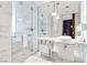 Bathroom featuring a large glass shower, double sink, modern fixtures, and bright marble tile at 4381 W Flamingo Rd # 1102/1104, Las Vegas, NV 89103