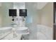 Modern bathroom featuring dual sinks, marble countertop, and wall-mounted televisions at 4381 W Flamingo Rd # 1102/1104, Las Vegas, NV 89103