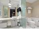 Modern bathroom with double sink, mirror TV, bright marble tile, and towel rack at 4381 W Flamingo Rd # 1102/1104, Las Vegas, NV 89103