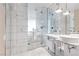 Modern bathroom featuring double sink, frameless shower, modern fixtures, and bright marble tile at 4381 W Flamingo Rd # 1102/1104, Las Vegas, NV 89103