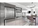 This modern kitchenette features stainless steel appliances, bright white tile, and dark wood table at 4381 W Flamingo Rd # 1102/1104, Las Vegas, NV 89103