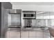 Modern kitchenette featuring stainless steel appliances, bright white tile, and ample counter space at 4381 W Flamingo Rd # 1102/1104, Las Vegas, NV 89103