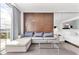 Contemporary living room featuring a sleek sofa, decorative wall panel, and floor-to-ceiling windows at 4381 W Flamingo Rd # 1102/1104, Las Vegas, NV 89103
