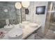 Modern bathroom featuring dual sinks, marble tile, and a flat-screen television for added luxury at 4381 W Flamingo Rd # 2302, Las Vegas, NV 89103