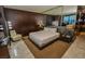 A cozy bedroom featuring a king-sized bed, wood wall, neutral color palette, and stylish furnishings at 4381 W Flamingo Rd # 2302, Las Vegas, NV 89103